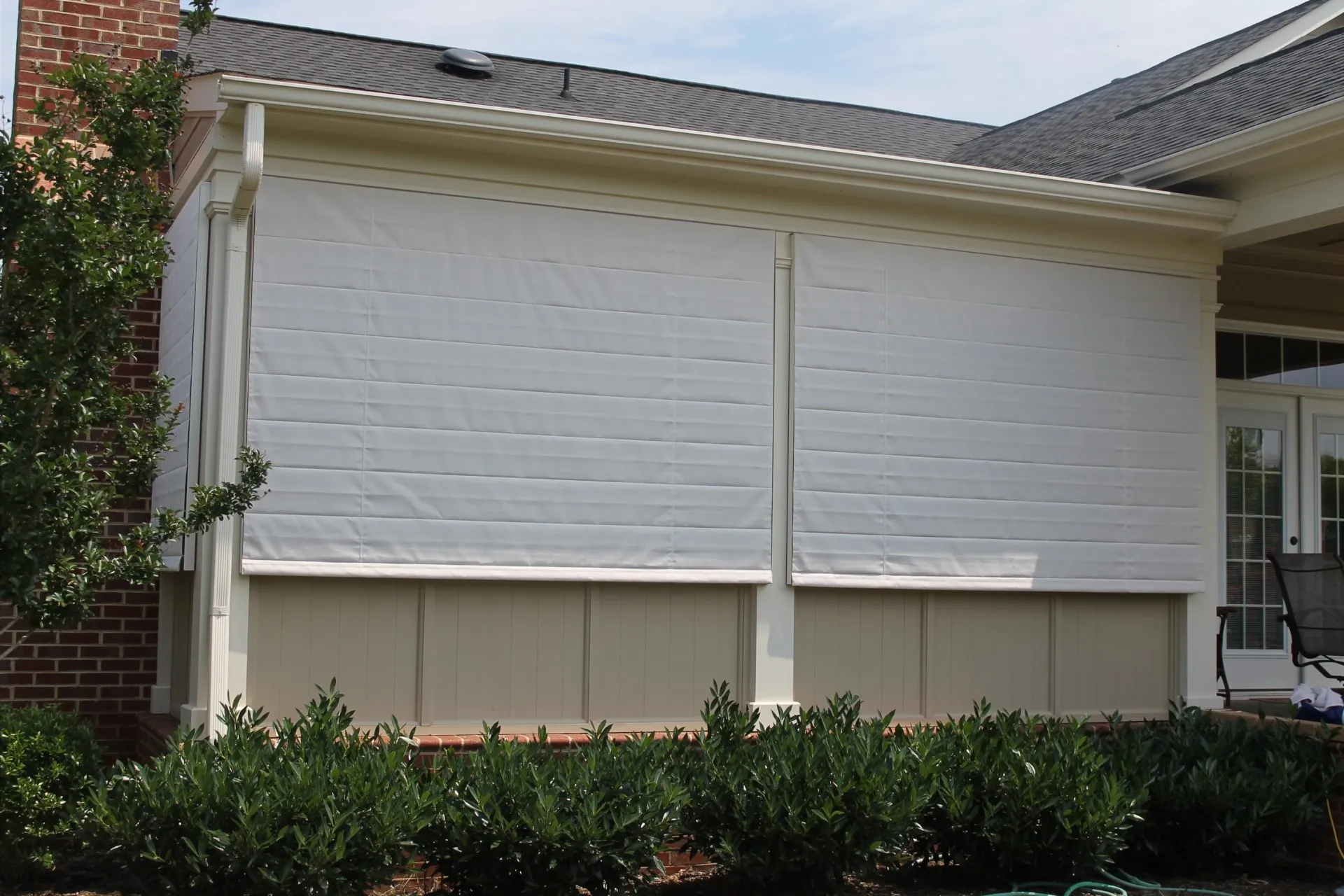 Front view closed A new screen porch addition to this carefully crafted home is protected with custom fabricated fold up Weather Queen® Exterior Screen Porch Shades